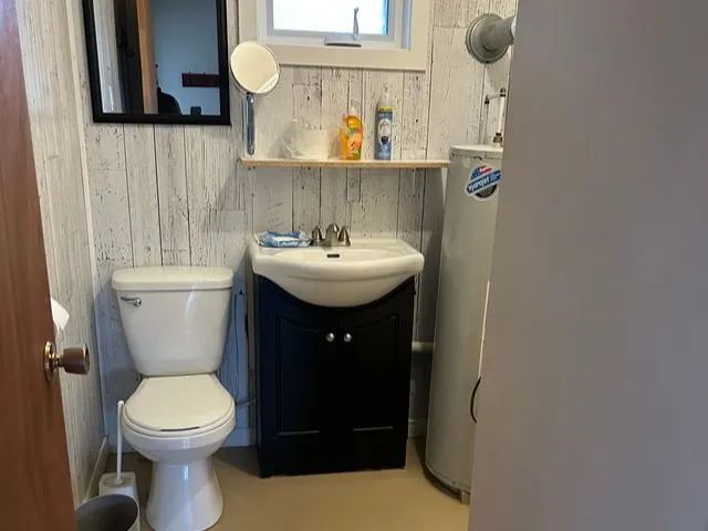 La salle de bain du lodge comprend une toilette et un lavabo avec meuble de rangement.