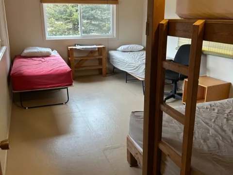 Cette chambre du lodge comporte plusieurs lits simples et un lit superposé pour accueillir les visiteurs.
