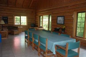 La salle à manger spacieuse du chalet Birch Haven avec ses murs en bois rond.