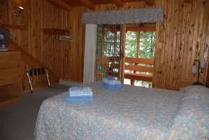 Cette chambre rustique avec lit double offre une vue directe sur la véranda extérieure.