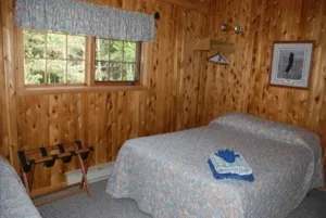 Cette chambre rustique est revêtue de bois et comprend un lit douillet pour votre séjour.