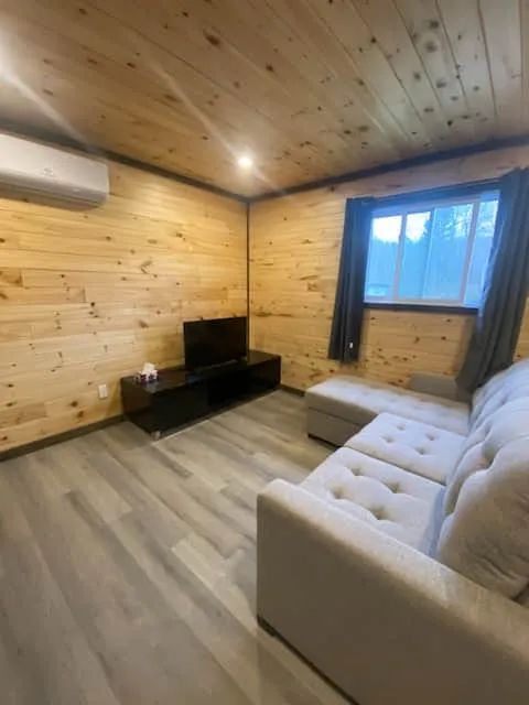 Le salon du chalet comprend un canapé confortable et une télévision.