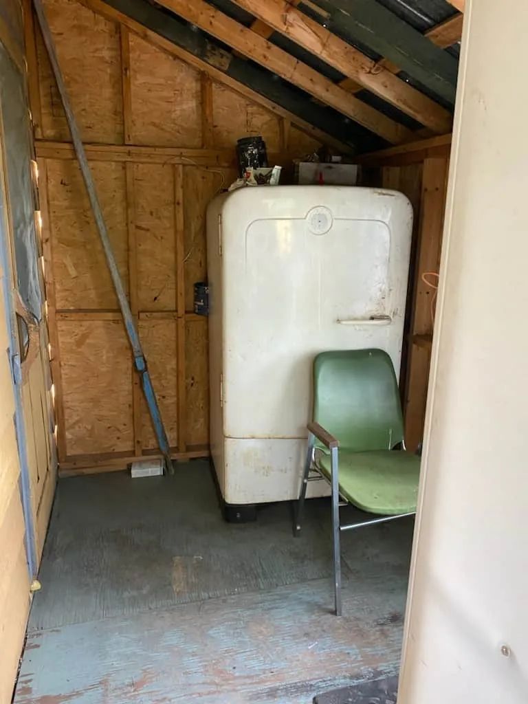 Un réfrigérateur d'époque est installé dans cet espace de rangement utilitaire.