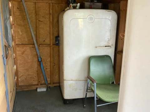 Un réfrigérateur d'époque est installé dans cet espace de rangement utilitaire.