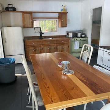 La cuisine équipée est adjacente à la salle à manger avec sa table en bois rustique.