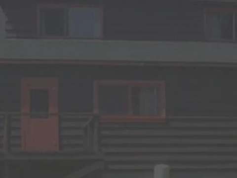 Exterior view of cabin 1 featuring its windows and door with contrasting red frames.