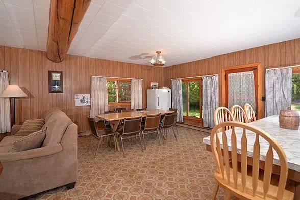 The open-concept cabin features a lounge area with a sofa and an adjoining dining space.