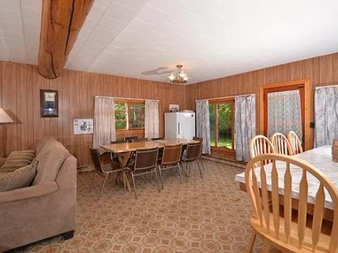 The open-concept cabin features a lounge area with a sofa and an adjoining dining space.