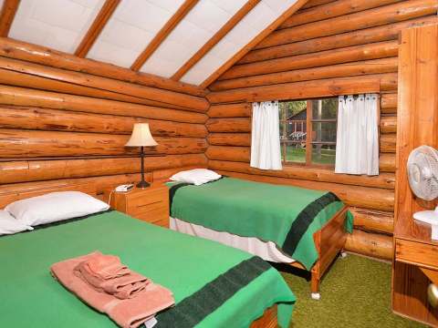 Cette chambre rustique du chalet comprend deux lits simples avec literie et serviettes.