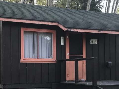 Vue extérieure du chalet numéro 11, une structure en bois avec une petite galerie devant.