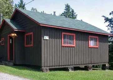 Vue extérieure du chalet 14, un bâtiment en bois avec une toiture verte.