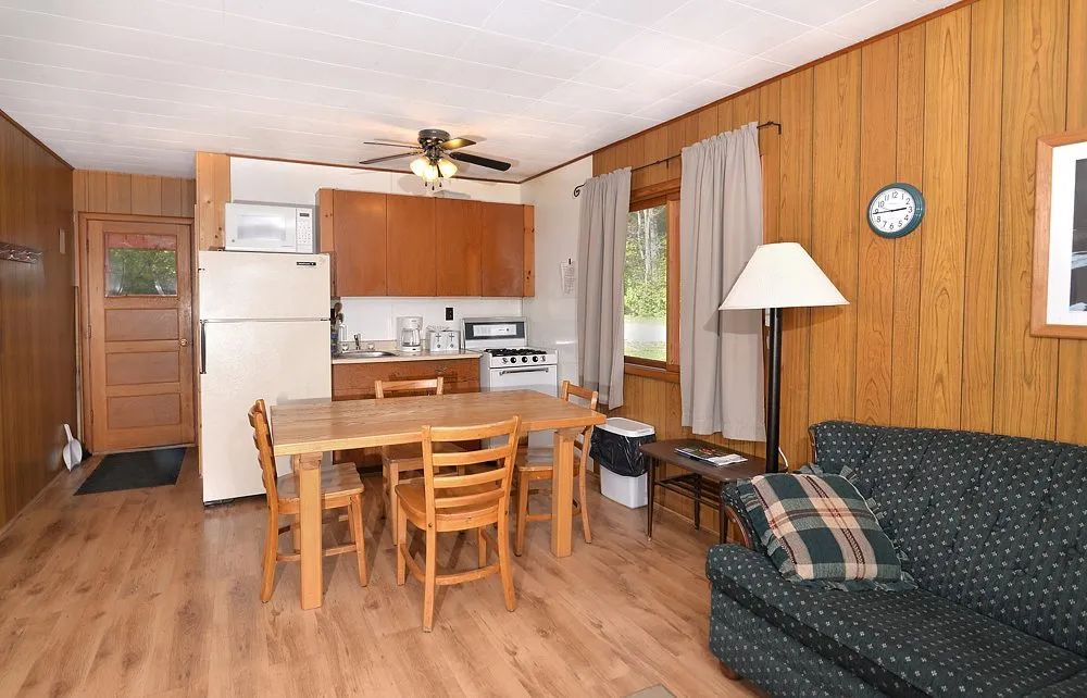 La cuisine et l'espace repas du chalet 14 sont équipés d'une table et d'un coin salon confortable.