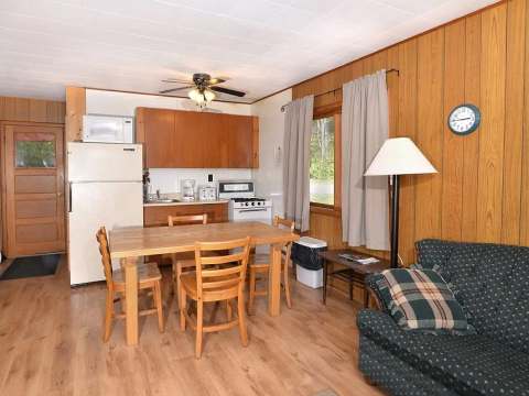 La cuisine et l'espace repas du chalet 14 sont équipés d'une table et d'un coin salon confortable.
