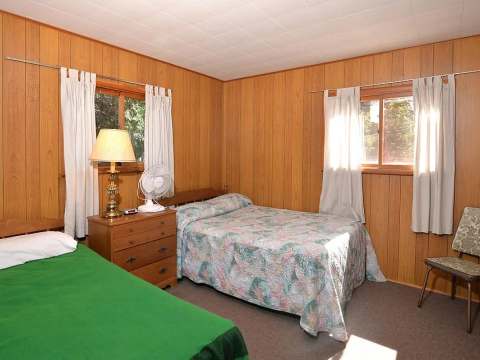 Cette chambre à coucher du chalet comprend deux lits simples avec des fenêtres lumineuses.