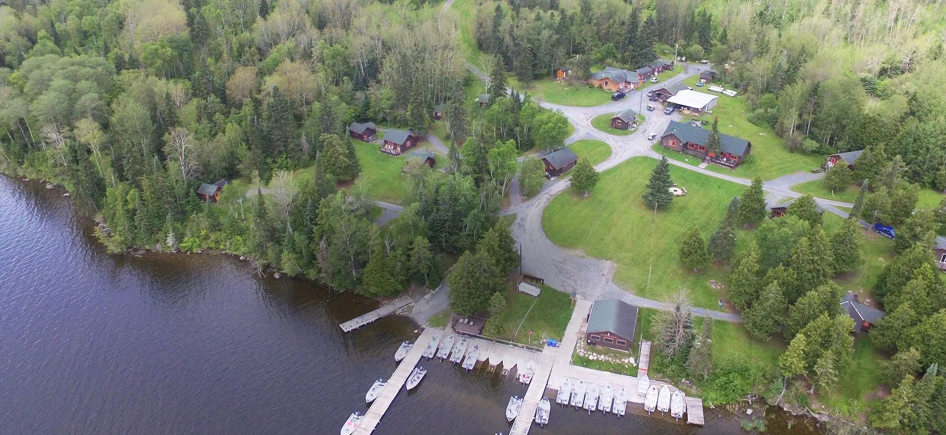 Vue aérienne de la pourvoirie et de ses chalets situés en bordure du lac.