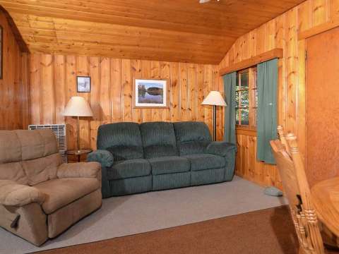 The living area of cabin 3 includes a sofa, a recliner, and a dining table.