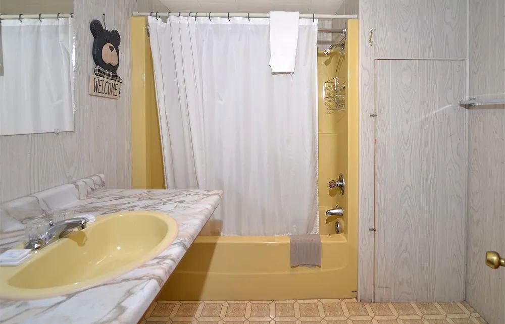 The cabin bathroom includes a bathtub with an integrated shower and a sink.