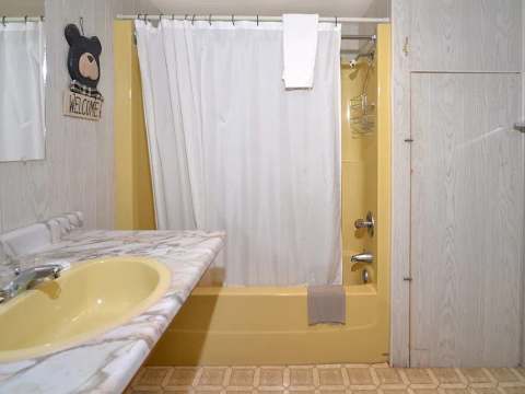 The cabin bathroom includes a bathtub with an integrated shower and a sink.