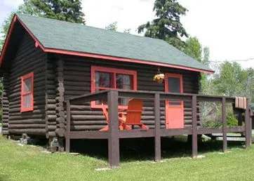 Exterior view of the log cabin with its deck and chairs.