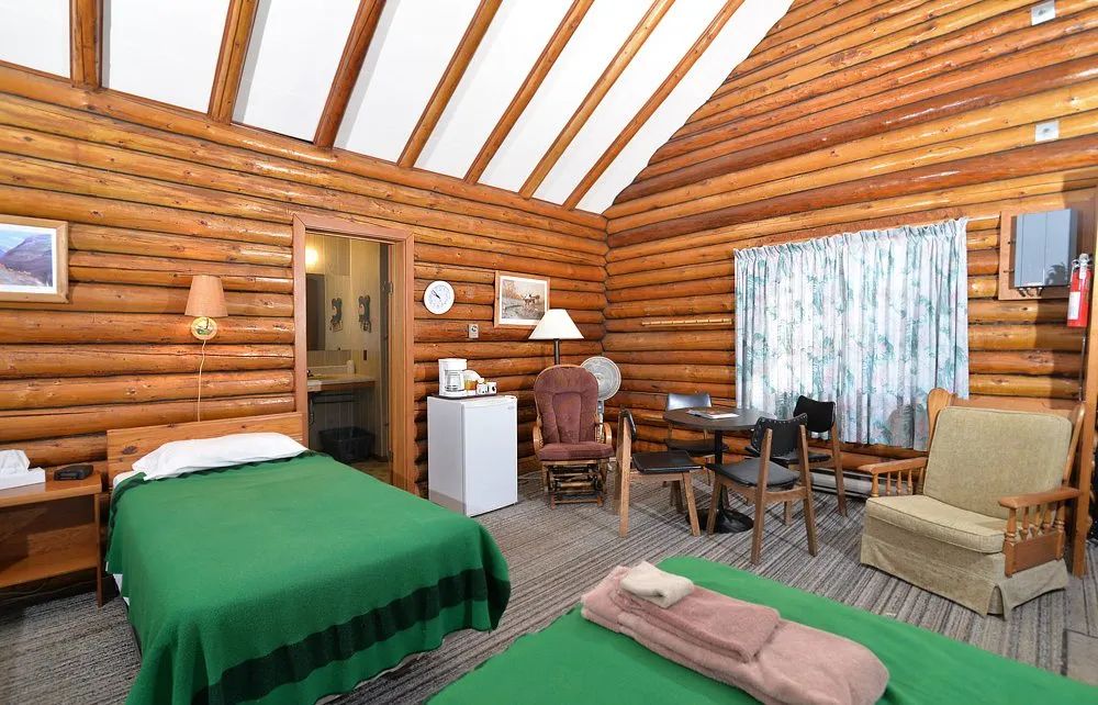 Interior view of the cabin featuring two beds, a dining table, and a small seating area.