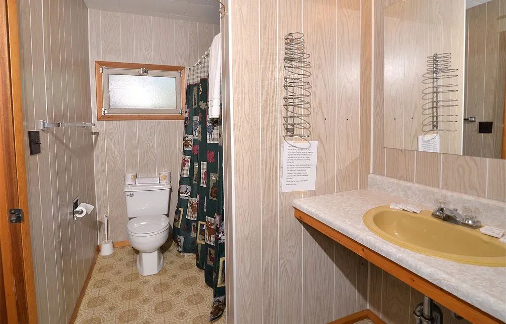 This private bathroom is equipped with a toilet, a sink, and a shower.