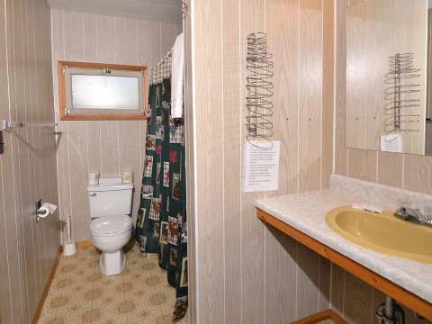 This private bathroom is equipped with a toilet, a sink, and a shower.