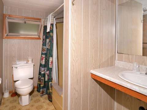 This private bathroom is equipped with a toilet, a sink, and a shower.