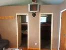 Interior view of the cabin showing access doors to the bedrooms and a wall-mounted television.