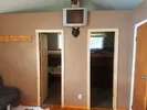 Interior view of the cabin showing access doors to the bedrooms and a wall-mounted television.