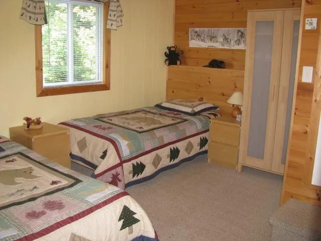This rustic bedroom features two single beds with themed bedding.