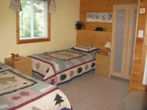 This rustic bedroom features two single beds with themed bedding.