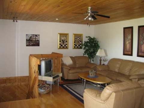 The cottage living room provides a comfortable relaxation area with sofas and a television.