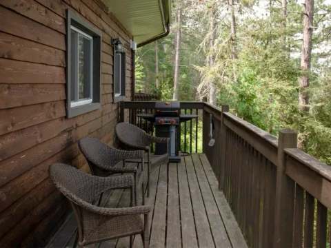 This suite features a private wooden deck equipped with armchairs and a barbecue grill.