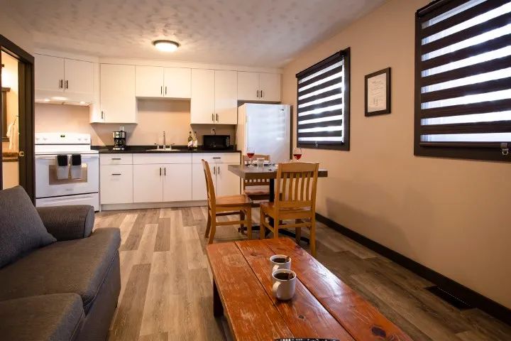 This suite features a full kitchen that opens onto a dining area and a living room.