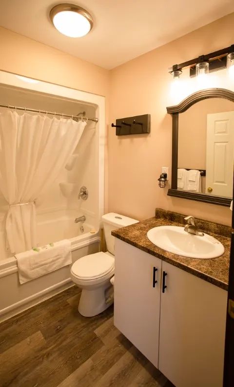 This suite bathroom features a bathtub with shower and an integrated vanity sink.
