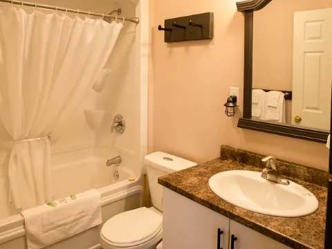 This suite bathroom features a bathtub with shower and an integrated vanity sink.