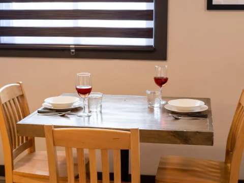 A small wooden table set for two people in the suite.