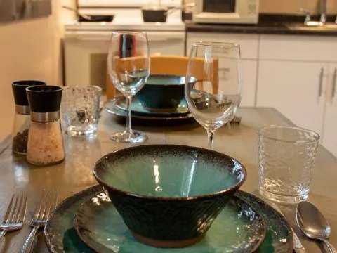 The suite's dining table is set in front of the equipped kitchen for your meals.