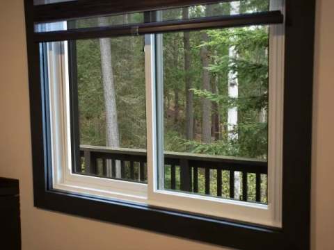 The suite window offers a view of the surrounding forest and the outdoor deck.