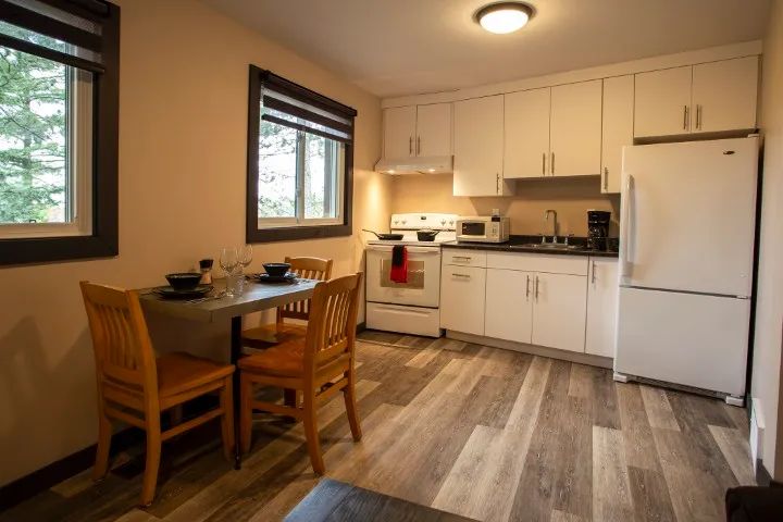 This functional kitchen includes a dining table and modern appliances.