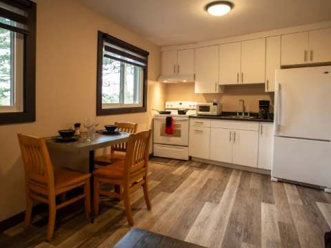 This functional kitchen includes a dining table and modern appliances.