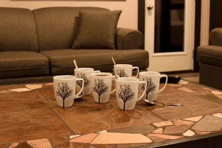 Coffee mugs are set on the coffee table in the suite's living room.
