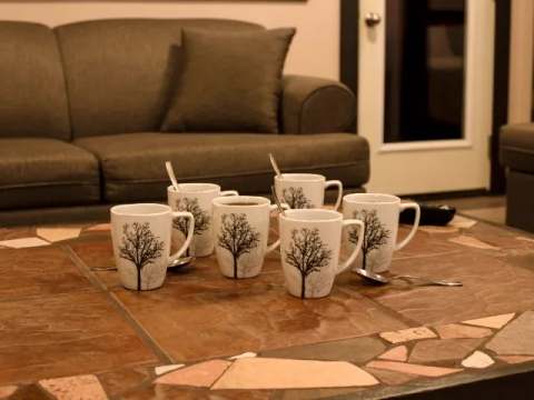 Coffee mugs are set on the coffee table in the suite's living room.