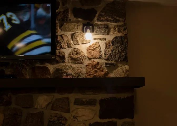 The suite's natural stone fireplace is equipped with a wall-mounted television.