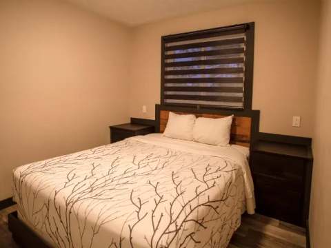 This suite features a comfortable bedroom with a queen bed and two nightstands.
