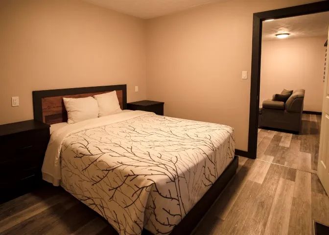 This suite includes a comfortable bedroom with a double bed and a view into the adjacent living area.