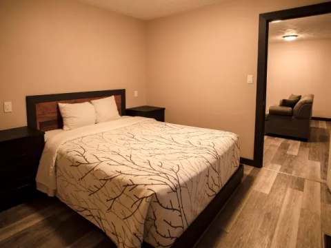 This suite includes a comfortable bedroom with a double bed and a view into the adjacent living area.