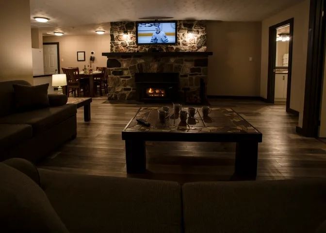 Living room of the suite with stone fireplace and dining area.