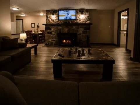 Living room of the suite with stone fireplace and dining area.