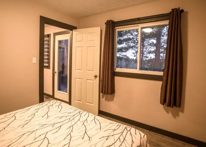 A view of the bedroom featuring the bed and a door leading to the private deck.